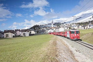 Red Colour Prints: The red train runs across the alpine village of Zuoz in spring