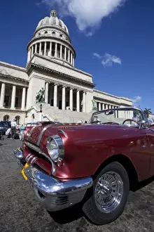 Vintage Car Prints: Red vintage American car parked opposite The Capitolio
