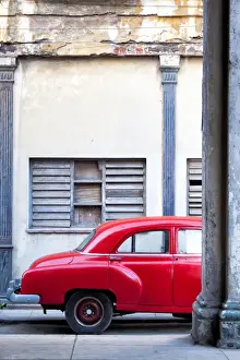 Vintage Car Prints: Red vintage American car parked on a street in Havana Centro