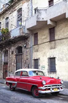 Red vintage American car parked on a street in Havana Centro, Havana, Cuba, West Indies, Central America