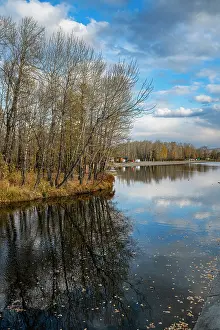 Season Prints: Reflecting water and trees in National Park Kyzyl in autumn with clouds above in Republic of Tuva Russia