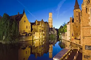 Reflection in canal of Belfort (belfry tower) illuminated at night, Old Town
