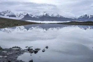 Altitude Prints: Reflection of daxue mountain range in lenggacuo lake with mount gongga above clouds in sichuan