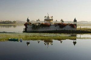 Dungarpur Prints: Reflection of temple in lake at dusk, with boat, Dungarpur, Rajasthan, India, Asia
