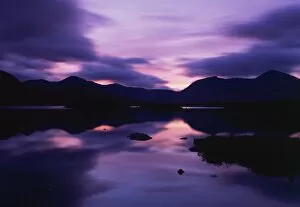 Dramatic Skies Collection: Reflections in the lake of sunset over dark hills of Rannoch Moor in the Highland region of