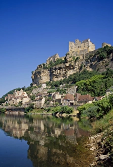 Reflections in the River Dordogne of the town and castle at Beynac, in Aquitaine