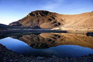 Stillness Prints: Reflections on still water in remote glacial lake below Cerro del Caballo in Sierra Nevada National Park in Spain