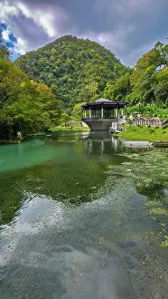 Waterscape Prints: Remodeled train station in a pond surrounded by green hills and trees in New Athon