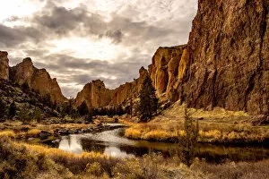 Moody Sky Gallery: A river running through a valley with large rock formations on either side, Oregon