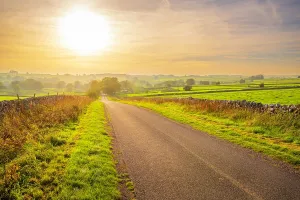 Route Prints: Road in autumn leads to Monyash in the Peak District of Derbyshire, England during sunset