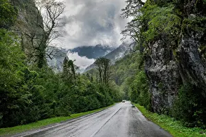 Fresh Prints: Road through dramatic mountains and lush greenery near Ritsa National Park in Russia