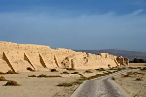 Surrounding Wall Prints: Road past ruined city wall of ancient Silk Road city of Gaochang, Taklamakan desert