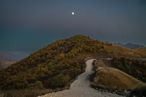 Trail Prints: Road winding through mountains under the night sky in Chechnya, Caucasus region of Russia