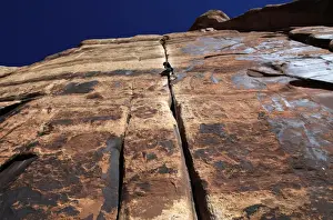 Rock Climber Prints: A rock climber tackles an overhanging crack in a sandstone wall on the cliffs of Indian Creek