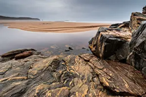 Rock formations at Sandwood Bay, with Am Buachaille sea stack in far distance, Sutherland