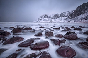 Boulder Prints: Rocks on the beach modeled by the wind surround the icy sea, Unstad, Lofoten Islands