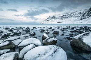 Blue Colour Prints: Rocks in the cold sea and snow capped mountains under the blue light of dusk, Unstad