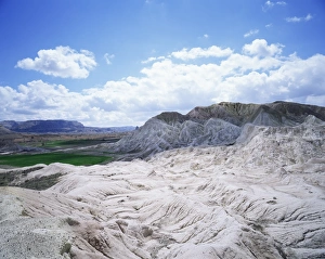 Arid Landscape Prints: Rocks and green fields in distance