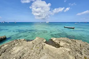 Calmness Prints: Rocky coastline in Cayman Islands with fishing boat in the transparent blue water