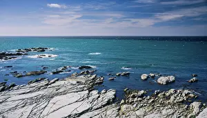 Crashing Prints: Rocky Shoreline and Vibrant Blue Ocean Waters Stretching Into the Horizon at Kaikoura Peninsula