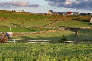 Romania Prints: Rolling hills and simple houses in rural Romania showcase countryside life in Maguri village during evening light