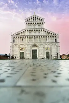 Romanesque facade of Pisa Cathedral (Duomo) under romantic sky at sunrise