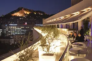 Bars Prints: Rooftop terrace bar at the Athens Hilton with Lykavittos Hill illuminated at night
