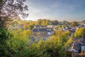 Exploring Prints: Rooftops of Tideswell during autumn with trees changing colors in the background in Derbyshire Peak District