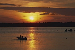 Rowing Boat Prints: Row boat silhouetted over Dragso bay at sunset in summer