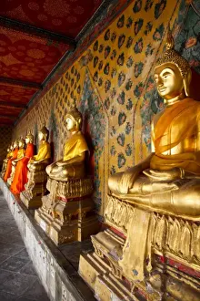 A row of golden seated Buddha statues located inside Wat Arun (The Temple of the Dawn)