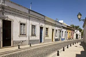 Single Storey Prints: A row of traditional cottages front a cobbled street in the walled town of Faro
