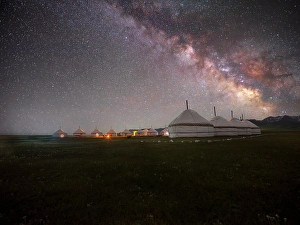 Vast Prints: A row of white yurts illuminated by the Milky Way