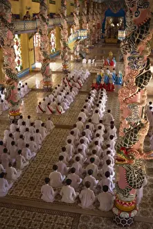 Tay Ninh Prints: Rows of monks at prayer inside a temple of the Caodai religious sect