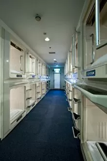 Rows and stacks of sleeping compartments along one corridor at a capsule hotel in Osaka