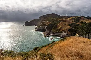 Zealand Prints: Rugged cliffs meet ocean waves at Cape Farewell on the South Island of New Zealand during cloudy weather