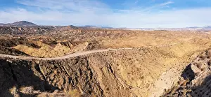 Granada Prints: Rugged desert landscape with dirt road in Gorafe