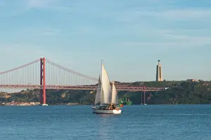 Tagus River Prints: Sailboat navigating on the Tagus River near the Ponte 25 de Abril, Belem, Lisbon