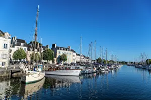 Sailboats Prints: Sailboats docked in a calm harbor under a clear blue sky with buildings lining the waterfront in France