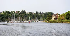 Sailboats Prints: Sailboats and yachts docked at a harbor in Dinan on the Rance estuary near green hills