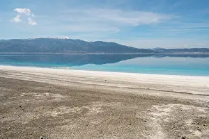 Destinations Prints: Salda Lake displays turquoise waters and white sand with mountains in the background during sunset in Turkey