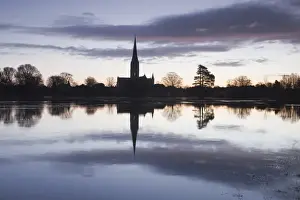 Salisbury cathedral at dawn reflecting in the flooded West Harnham Water Meadows, Salisbury, Wiltshire, England, United Kingdom, Europe