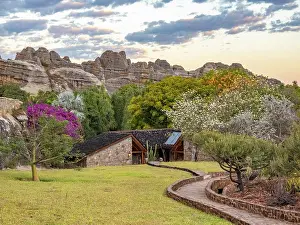 Madagascar Prints: Sandstone formations provide backdrop for Relais de la Reine Hotel in Madagascar during sunset with lush vegetation