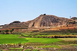 Cultivation Prints: Sandstone formations rise above green fields in Isalo National Park in Madagascar under a clear blue sky