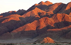Sesriem Prints: Sandstone mountains lit by the last rays of light from the setting sun