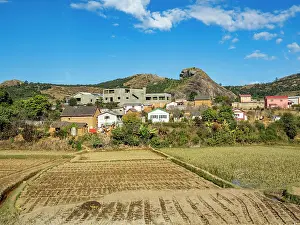 Madagascar Prints: Scenery along highway N2 from Antanavarino to Andasibe in Madagascar features homes and fields under blue sky