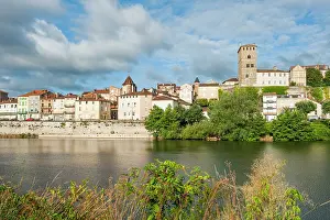 Riverside Prints: Scenic view of Cahors along the Lot River in southwest France with historic buildings and clouds