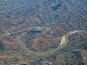 Madagascar Prints: Scenic view from charter flight showcasing river winding through mountains in Madagascar