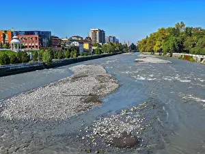 Parks Prints: Scenic view of Terek river in Vladikavkaz with rocky banks and city skyline on a clear day