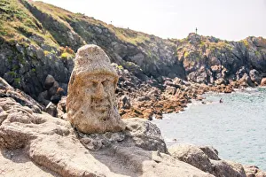 Saint Prints: Sculpted stone face overlooks sea on rocky coast near Saint Malo in Brittany France during sunny weather