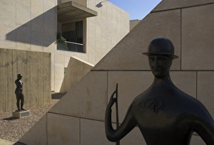 Two sculptures in front of geometrical walls of museum facade Two sculptures in front of geometrical walls of museum facade